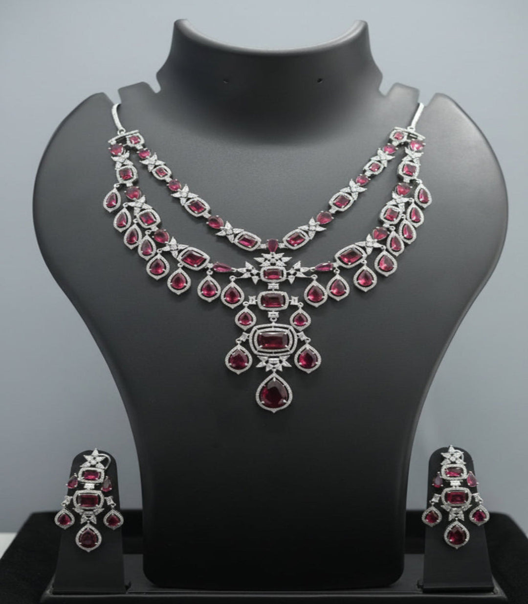 Jewelry set with necklace and earrings on a mannequin bust against a black background
