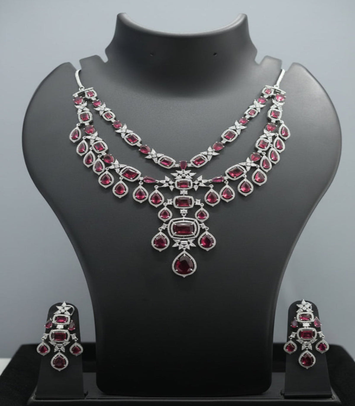 Jewelry set with necklace and earrings on a mannequin bust against a black background